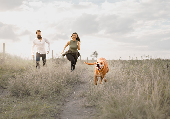 Rinnai lifestyle. Coppia che corre con il cane nella natura.